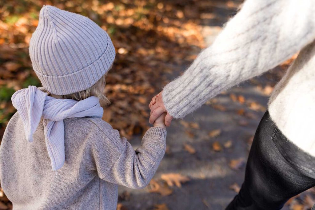 Kind mit Strickmütze und Schal in Naturtönen beim Familienshooting